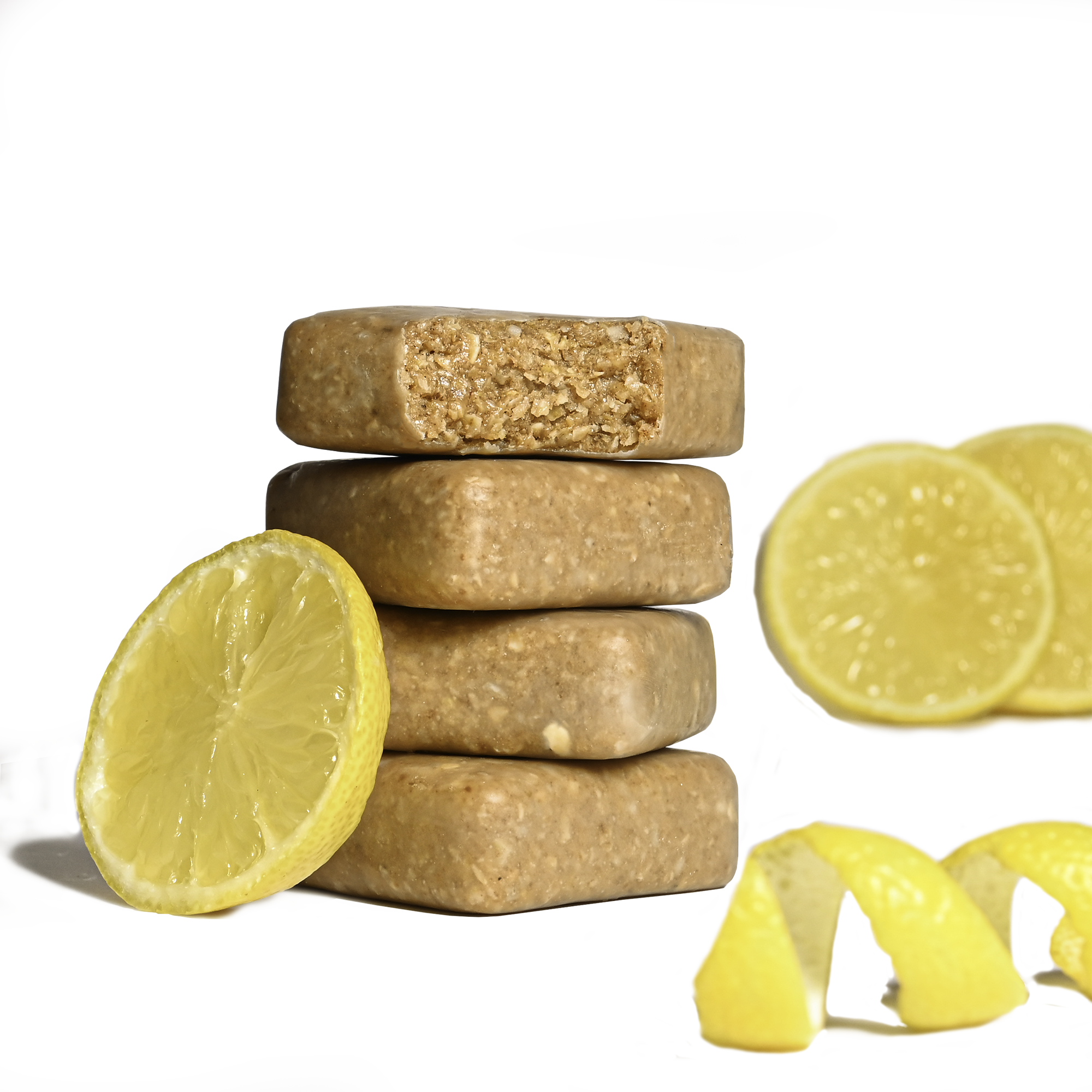 Stack of Performance² Dual-Carb & Electrolyte Energy Bars with lemon slices and a squeezed lemon on a white background.